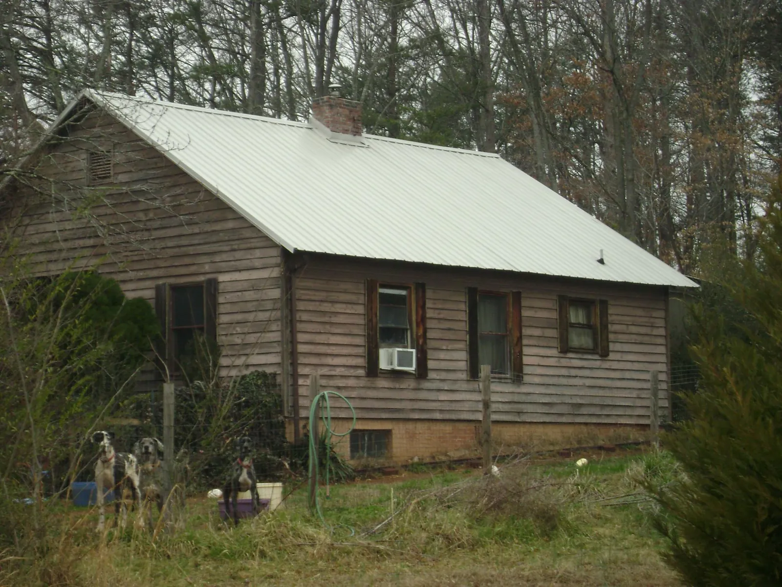 White metal roof on an old wood sided farmhouse, from a Metal Roof Installation job in Bristow
